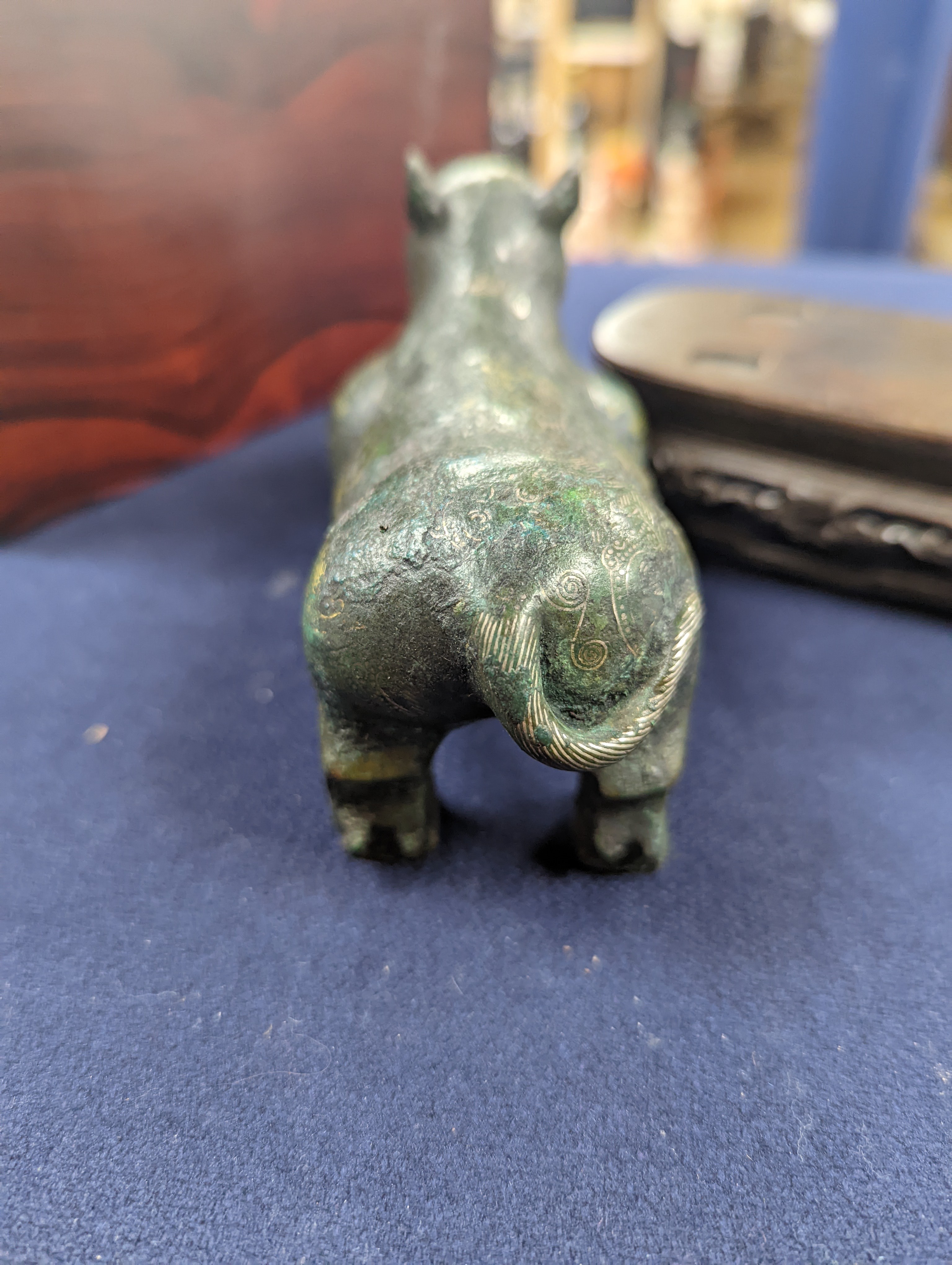 A Chinese gold and silver inlaid bronze figure of a tapir, Han dynasty or later, L. 12cm, excluding hardwood stand and fitted box